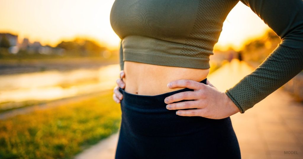 woman standing showing off her tight stomach (MODEL)